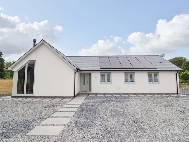 A house with solar panels and a gravel pathway at Kingfisher 