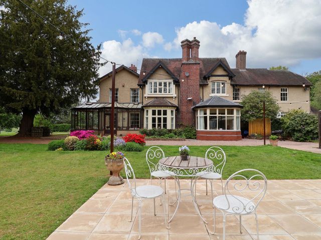 A garden with a house, table, and chairs at Parkfields House in Stoke-on-Trent