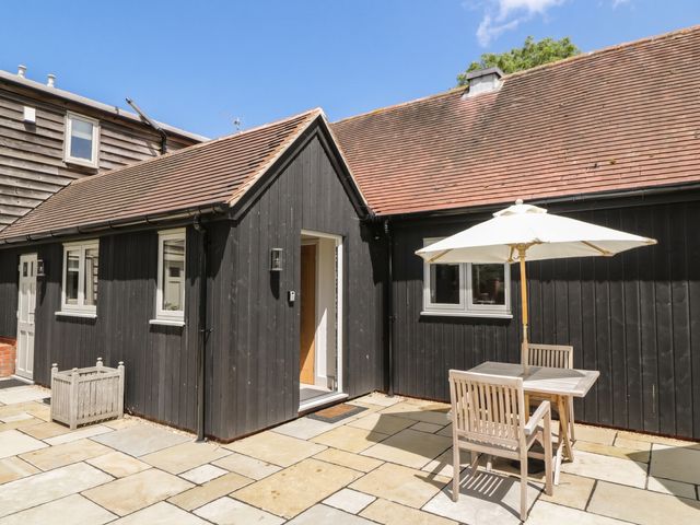 An outdoor area with a table and umbrella at Foxglove in Stratton Audley near Bicester