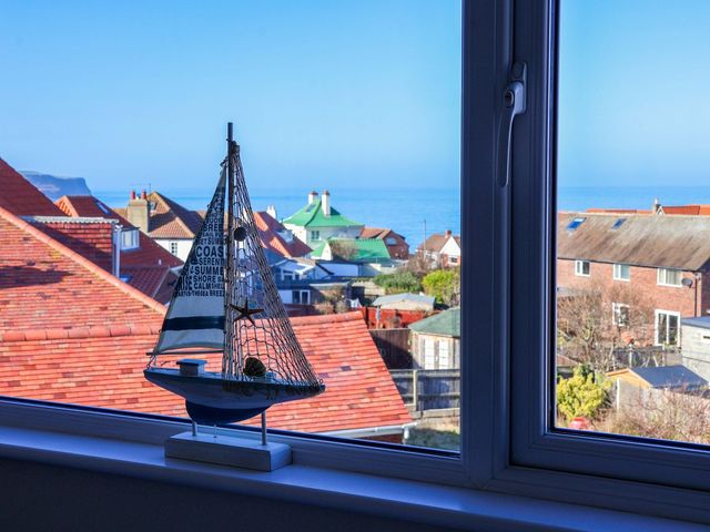 A living room with a sailboat model near a window at Beachcrest in Whitby