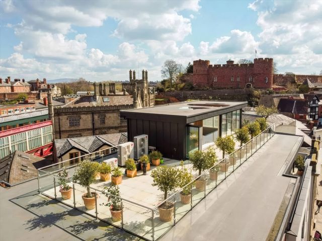 A rooftop with planters and a view of a castle at The Penthouse in Shrewsbury