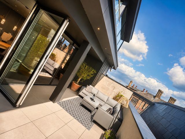A balcony with a sofa and potted plant at Luxury two story Penthouse with roof top terrace in Shrewsbury