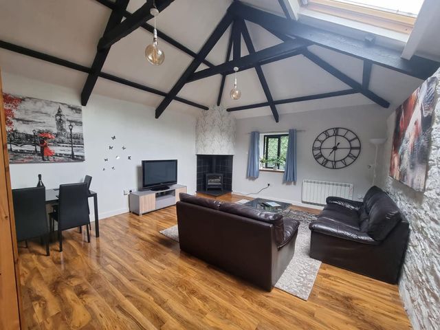 A living room with a sofa, chairs, table, and television at the property