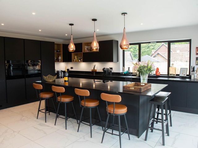 A kitchen with an island and bar stools at House Sleeps 10 with Enclosed Garden