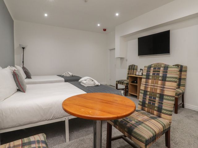 A bedroom with two beds and a table at Luxury Winter Gardens Apartment 1 in Blackpool
