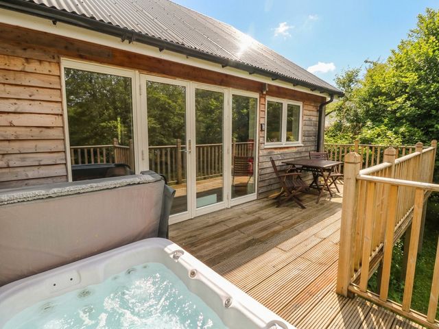 An outdoor area with a hot tub and dining furniture at Almond in Killin