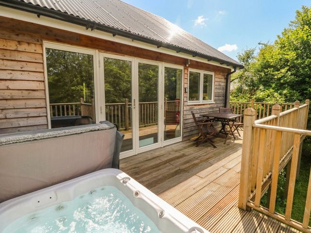 An outdoor area with a hot tub and seating at Garth Cottage in Killin