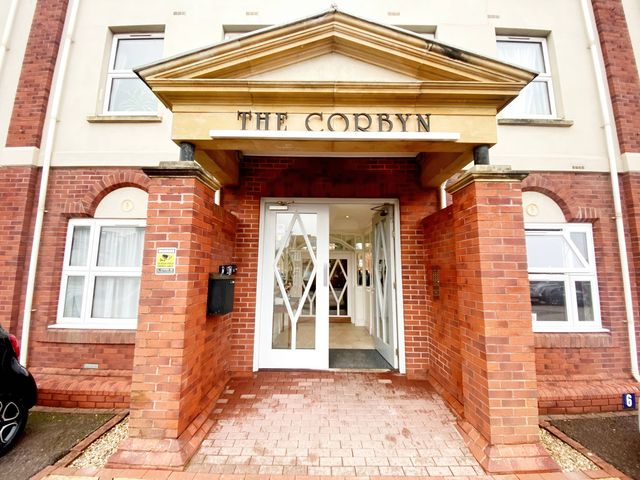 An entrance with a sign and double doors at The Corbyn in Torquay