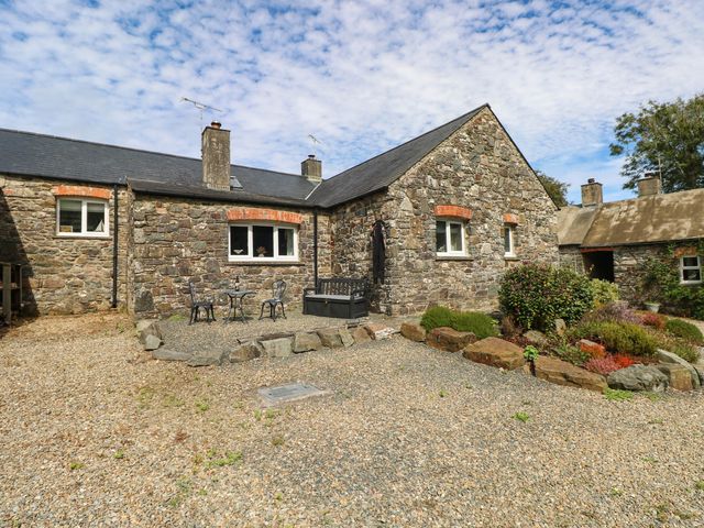 An outdoor area with stone walls and seating space at The Old Dairy near Solva
