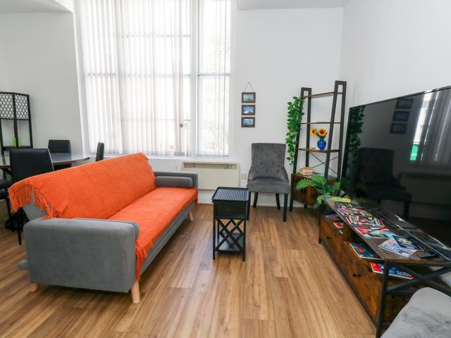 A living room with a sofa and television at Ocean Breeze in Weymouth
