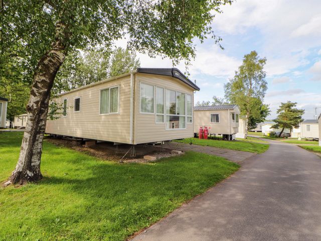 A caravan surrounded by grass and trees in Caravan, 