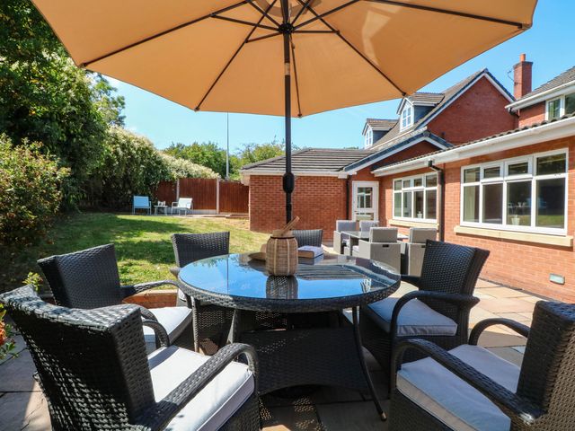 A garden with a table and chairs under an umbrella at The Ferns in Kirkham