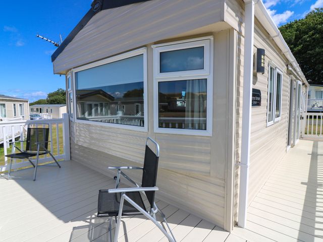 A mobile home with a deck and chairs at Rowan View 251
