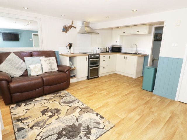 A kitchen with a sofa and appliances at The Hideaways in Tyn-y-Gongl