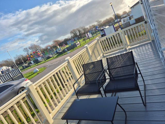 An outdoor area with chairs and a table overlooking a playground at Unity Beach Burnham-on-Sea