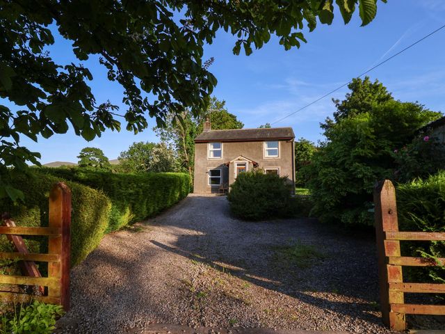 A house with a gravel driveway and gate at Robin Hood Farmhouse in Keswick