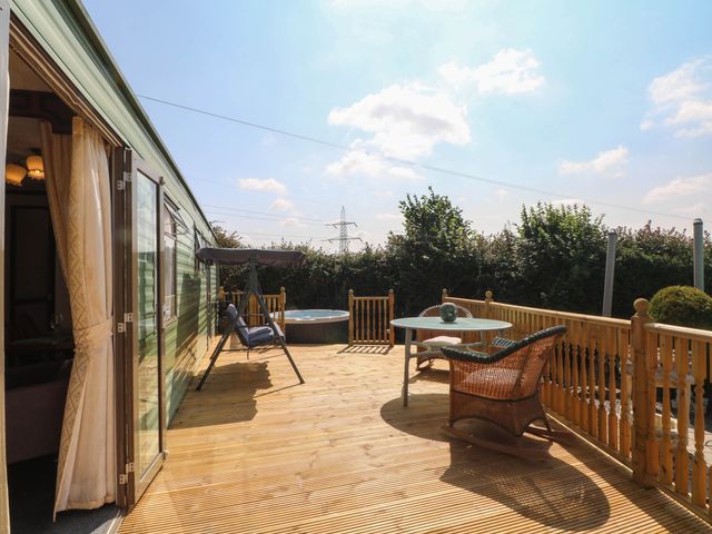 An outdoor area with a hot tub and seating at Buzzards Retreat in Wrexham