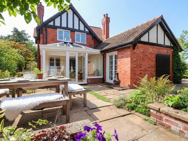 A garden with a table and chairs at Lyneal Cottage Ellesmere