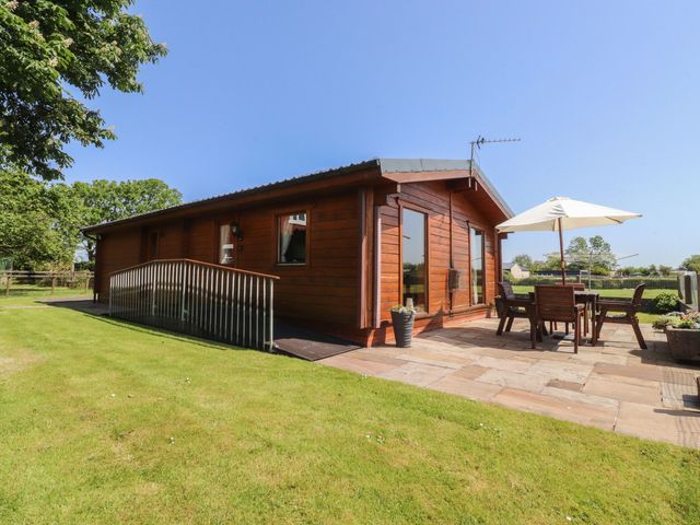 A lodge with a patio area and outdoor furniture at Chestnut Lodge in Pilling near Stake Pool