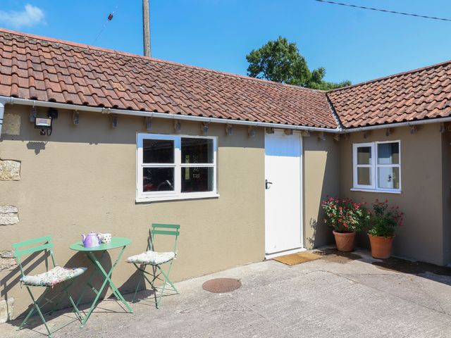 A patio with a table and chairs at The Old Dairy in Corsley near Warminster