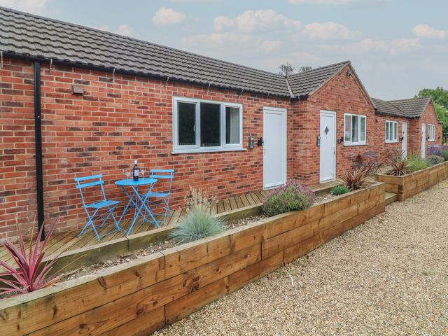 An outdoor area with a brick building and blue chairs at Kirkstead, Billinghay, Lincolnshire