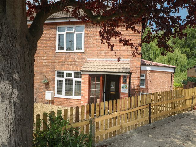 A brick house with white windows and a door at The Kingfisher Falls in Melton Mowbray