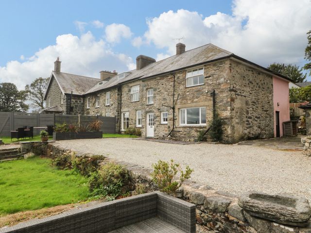 An outdoor area with a stone house and garden at Ty Mawr in Criccieth