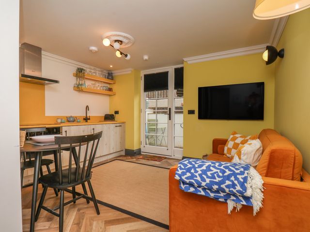 A living room with a kitchen and dining area at Apartment Yellow in Whitby