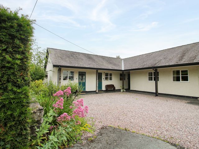 An outdoor area with a gravel driveway and flower beds at Apartment 1 in Lydbury North