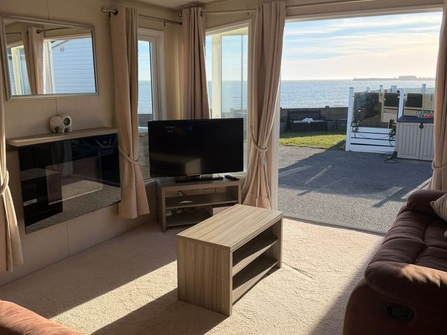 A living room with a sofa and a tv at Trecco Bay holiday park, Porthcawl