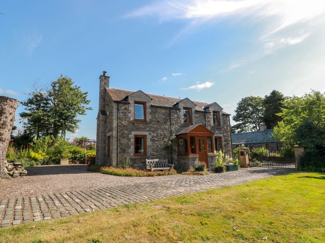 A house with a gravel driveway and garden at Buchanan’s Bothy in Glencarse