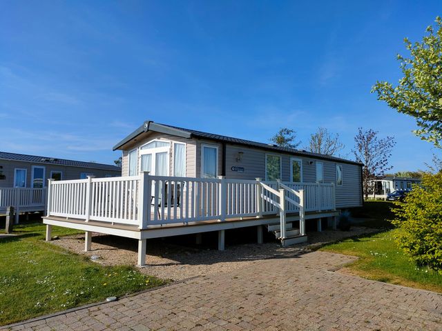 A caravan with a decking area at Primrose Valley Park - Pebbles Retreat in Primrose Valley