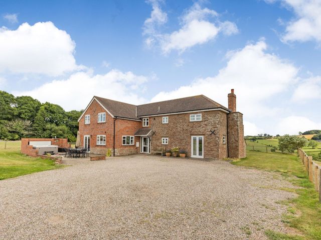A house with a patio and seating area at Wood Cottage in Tenbury Wells