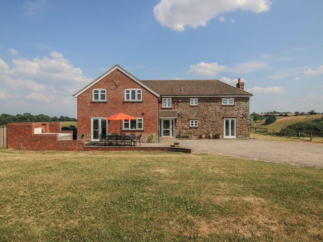 A house with a terrace and outdoor seating at Wood Cottage in Tenbury Wells