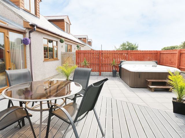 An outdoor area with a dining table and chairs at 1 The Old Smithy Cemaes Bay