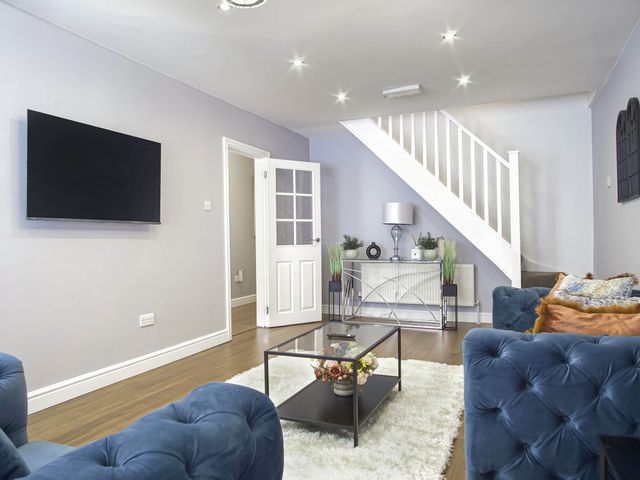 A living room with a television and sofas at Cozy Riverside Retreat in Snodland