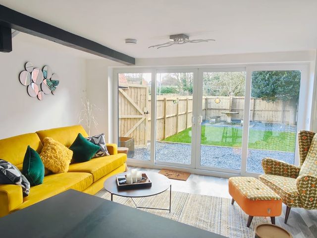 A living room with a sliding door and outdoor view at The Old Barn in Manchester