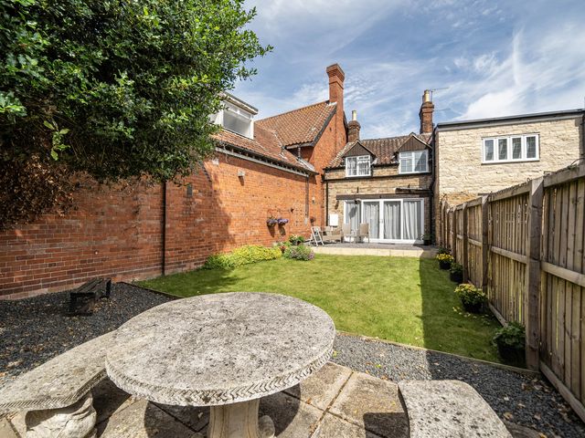 A garden with a table and seating area at Captivating 2 Bed House in Nettleham
