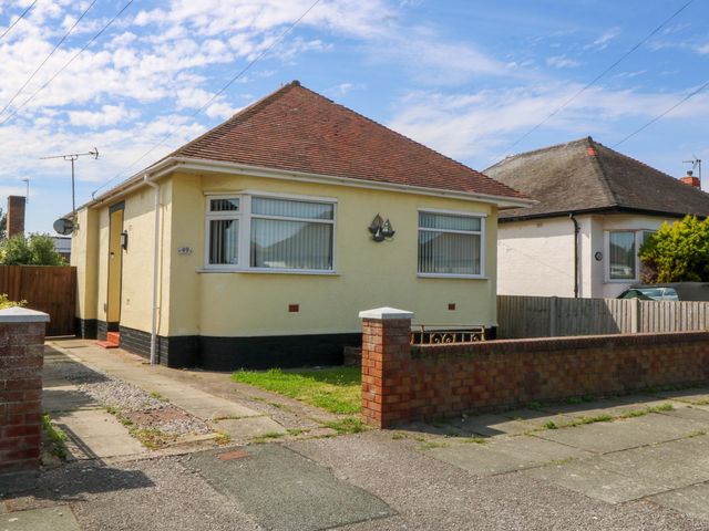 A bungalow with a driveway and pathway at Seaside Bungalow in Rhyl