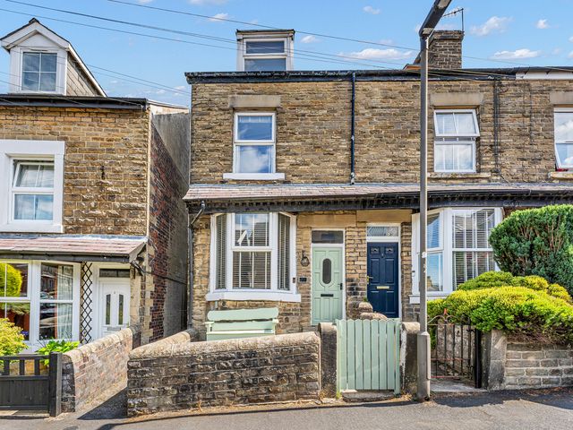 A brick house with two front doors and a garden at Peak Side Terrace in Buxton