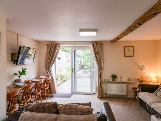 A living room with a dining area and access to the garden at Owl in Pickering