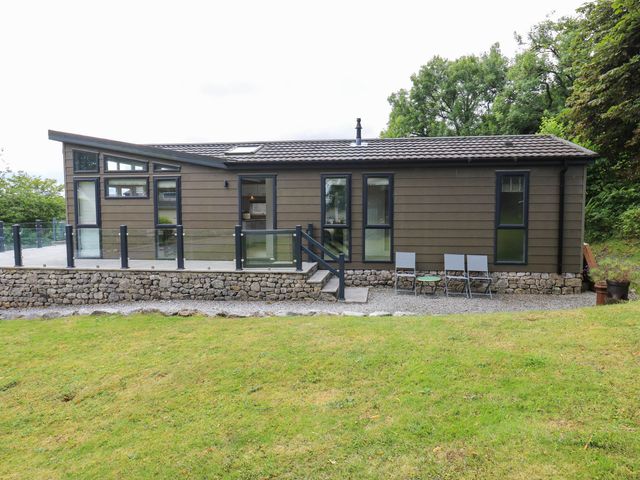 An outdoor area of a building with a stone wall and chairs at Dales Retreat Threshfield near Grassington