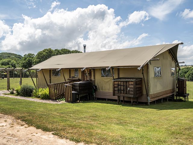 A tent with wooden platform and outdoor seating at Luxury Safari Lodge Sleeps 4/6 Deer Park Dogs Ok Zeal Monachorum near Bow