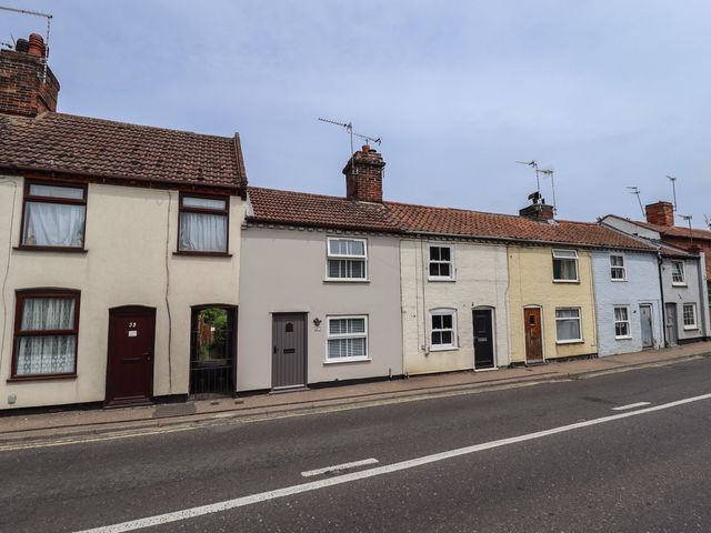 A row of houses with doors and windows on a street at Pax Cottage in 