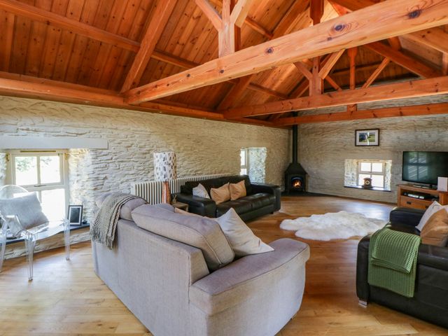 A living room with a sofa and television at Yr Hen Felin in Boncath