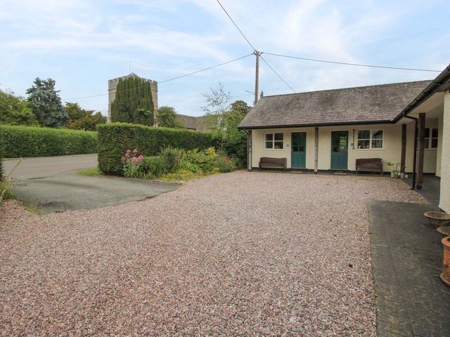 An outdoor area with a gravel driveway and flower beds at Apartment 3 in Lydbury North