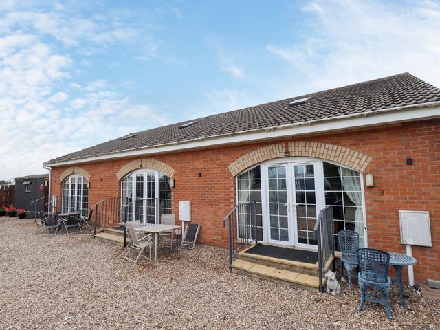 An outdoor view of a brick building with seating at Holiday Cottage 1 in Skegness