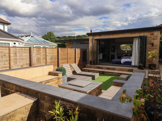A garden with seating and a view of the building at The Annexe in Shipley