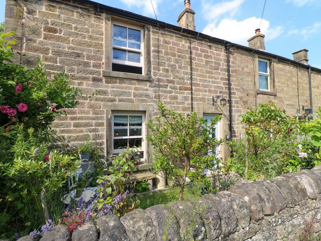 A stone cottage with flowers and plants outside at Sunnyside in Elton