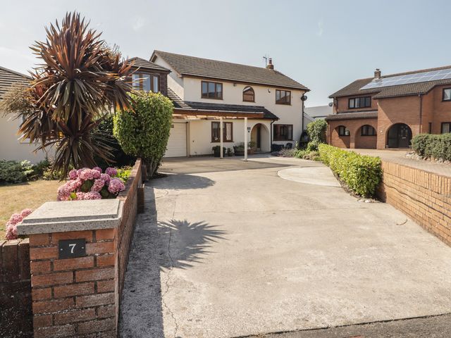 A house with a garage and driveway at Ty Traeth in Porthcawl